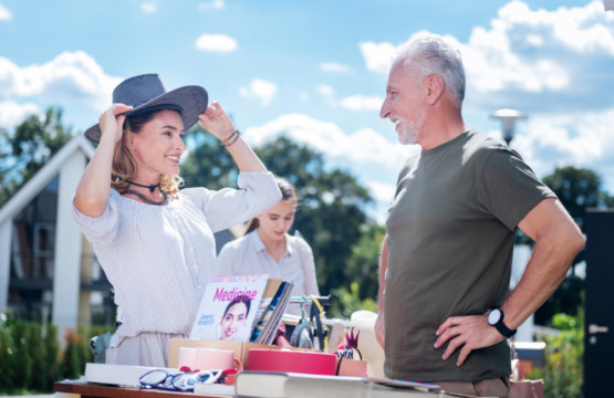 A woman is conversing with an older man at the Annual Yard Sale at Hampton Plaza.