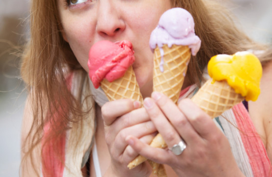 A woman enjoying ice cream cones during summertime.