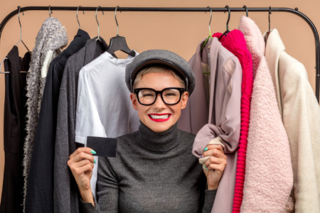 A woman holding a credit card while browsing clothes at a downtown Towson store during Fall Fun.