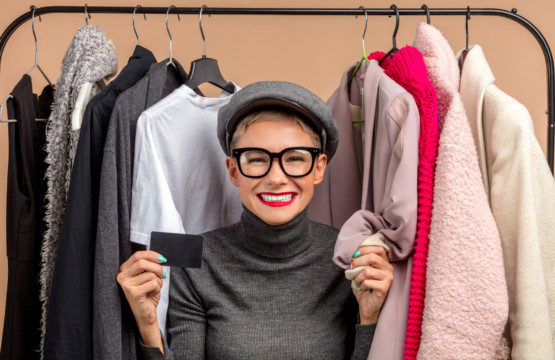 A woman holding a credit card while browsing clothes at a downtown Towson store during Fall Fun.