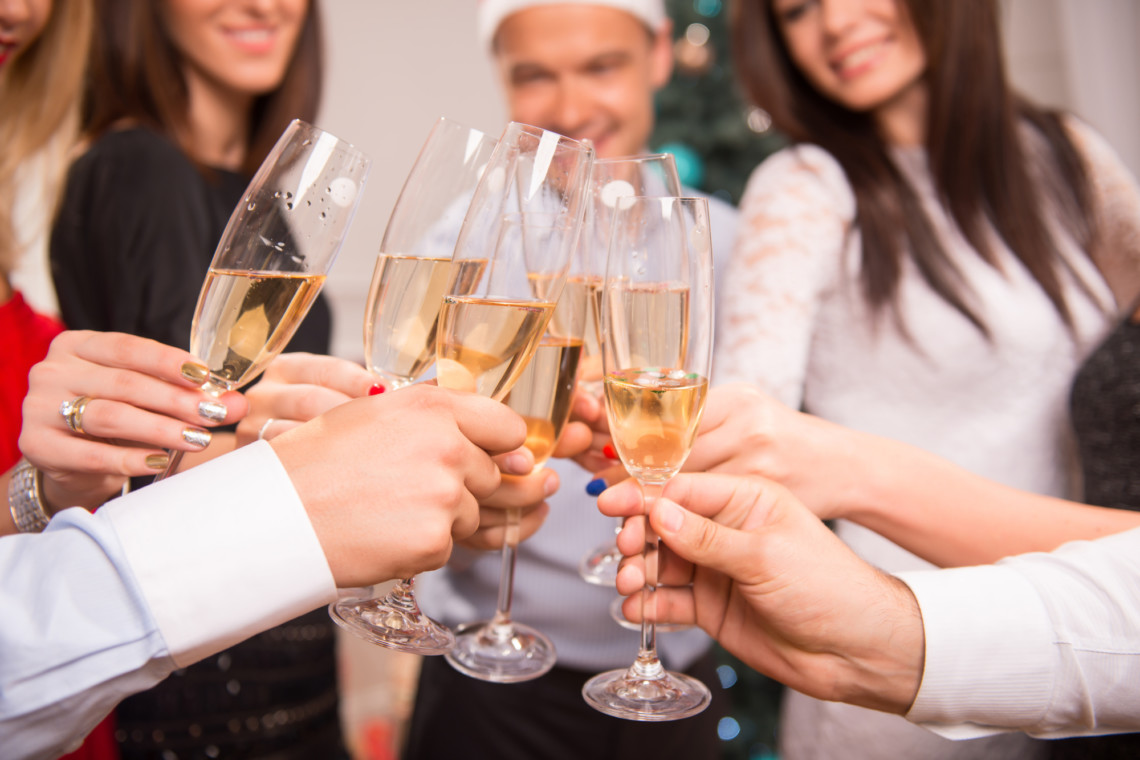 Hampton Plaza Holiday Cocktail Party attendees toasting champagne glasses.