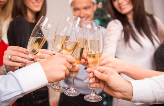 Hampton Plaza Holiday Cocktail Party attendees toasting champagne glasses.