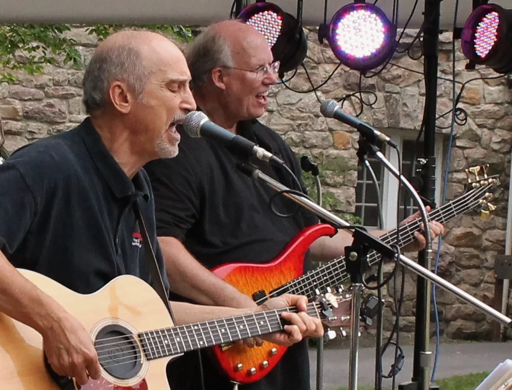 Two musicians performing live music in the Hampton Plaza Courtyard.